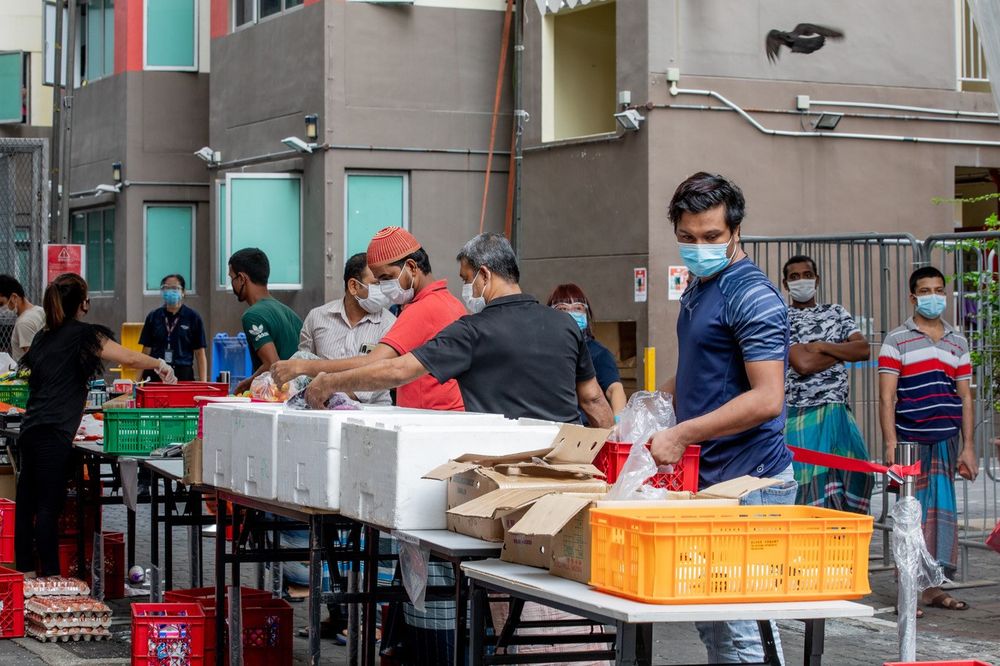 Migrant workers at Westlite Toh Guan Dormitory collecting groceries, with officials on hand to ensure they follow safe distancing measures, on June 12, 2020. — TODAY pic