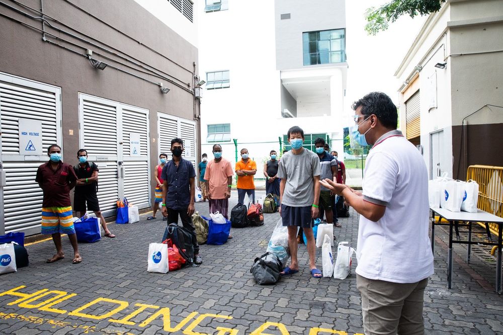 Westlite Toh Guan Dormitory operator Vasudavan Krishnan (right) giving a welcome speech to workers before they head up to their rooms on June 12, 2020. — TODAY pic