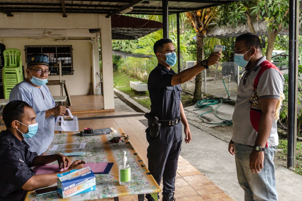 Malaysian Muslims have their temperature checked at the entrance of the Al-Hidayah Mosque during recovery movement control order in Kampung Sungai Penchala, Segambut June 12, 2020. u00e2u20acu201d Picture by Firdaus Latif
