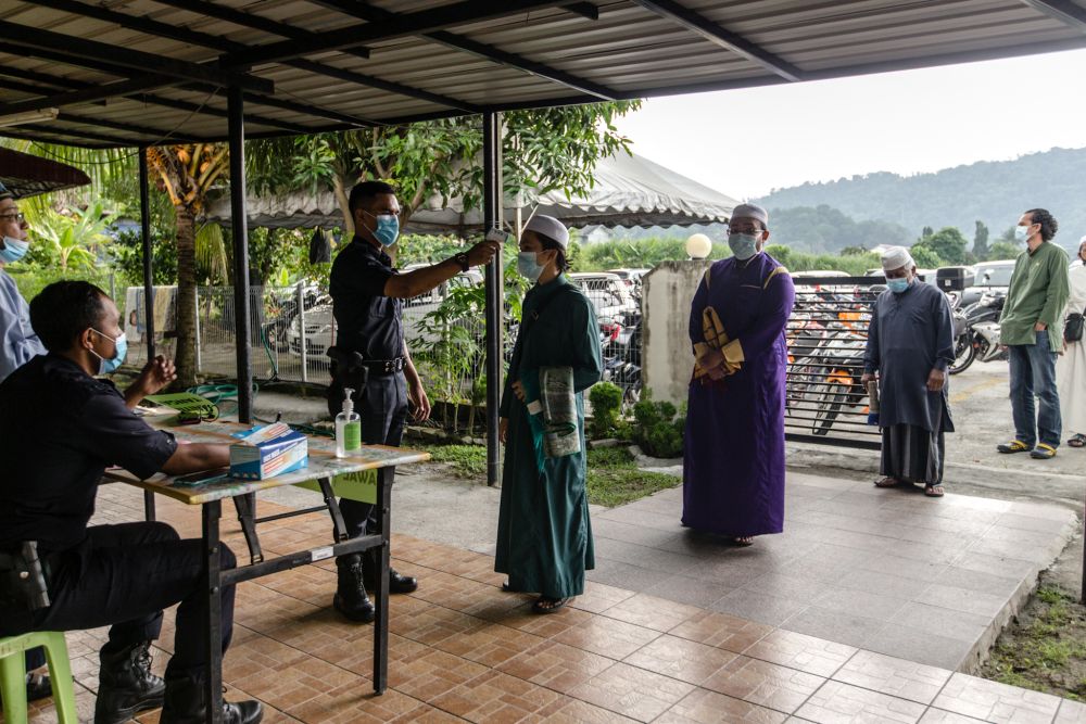 Malaysian Muslims have their temperature checked at the entrance of the Al-Hidayah Mosque during recovery movement control order in Kampung Sungai Penchala, Segambut June 12, 2020. u00e2u20acu201d Picture by Firdaus Latif