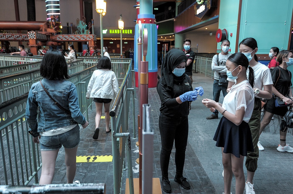  RWG staff sanitising visitors' hands, checking temperatures and ensuring social distancing at the entrance to the indoor theme park. June 19, 2020.