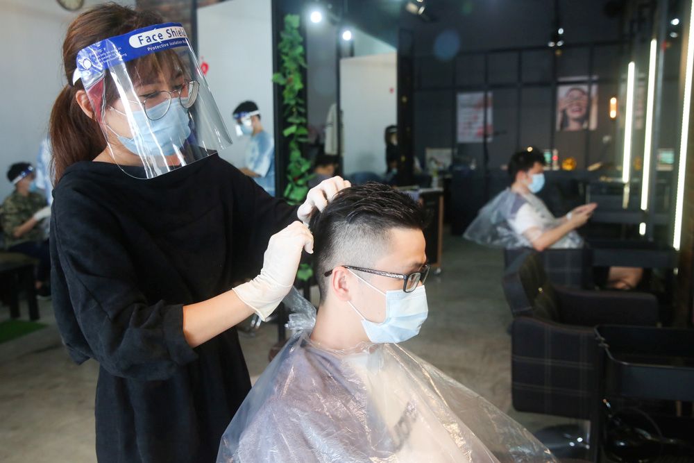 Hairstylist Lyz Tham tends to a client at the Eighty Ninth Hair Studio June 10, 2020. u00e2u20acu201d Picture by Choo Choy May 