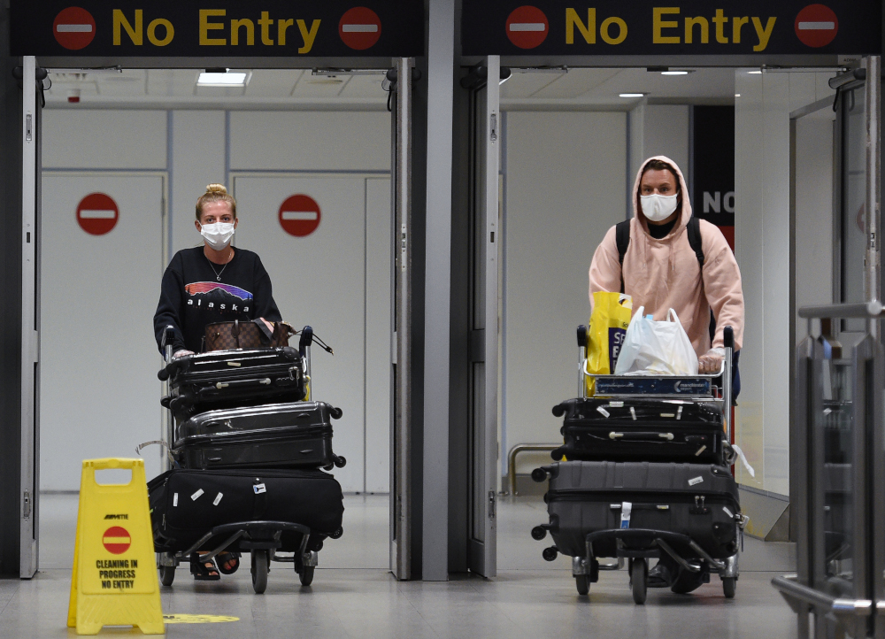 Passengers wearing personal protective equipment, including a face mask as a precautionary measure against Covid-19, arrive at Terminal 1 of Manchester Airport in northern England, June 8, 2020. u00e2u20acu201d AFP pic 
