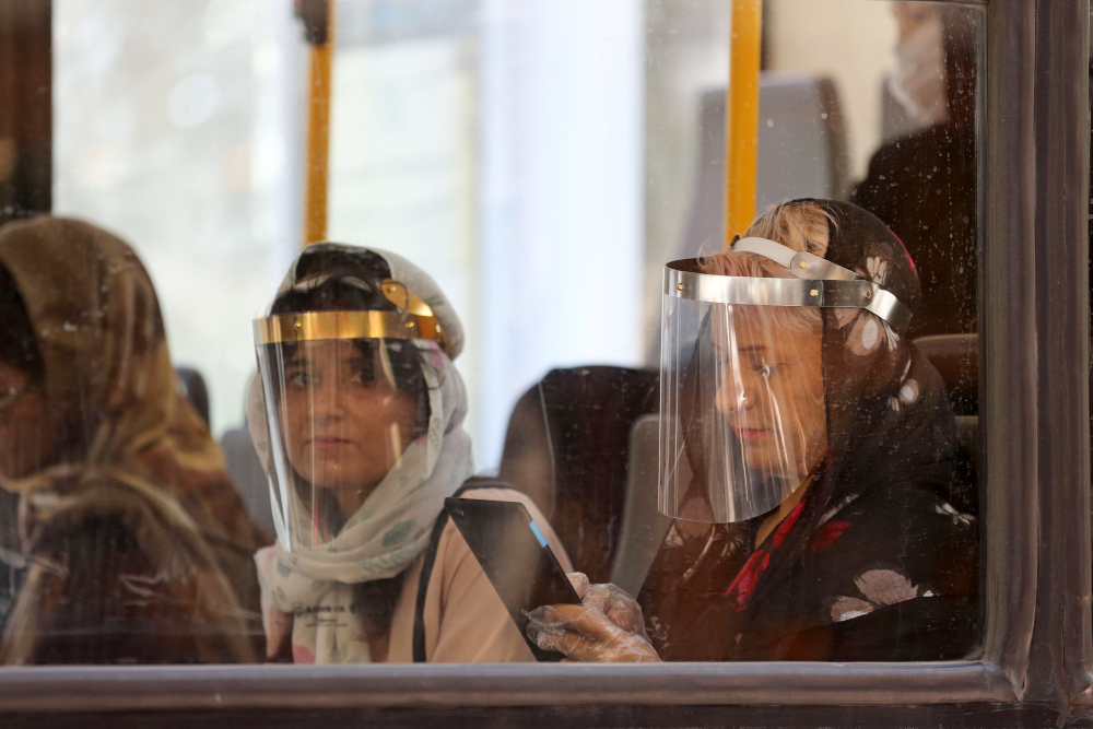 Passengers, wearing face shields due to the Covid-19 coronavirus, sit inside a bus in the Iranian capital Tehran June 22, 2020. u00e2u20acu201d AFP pic