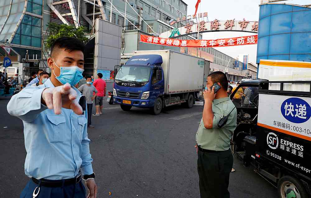 Security guards wearing face masks stand outside the Jingshen seafood market which has been closed for business, in Beijing, China June 12, 2020. u00e2u20acu201d Reuters pic