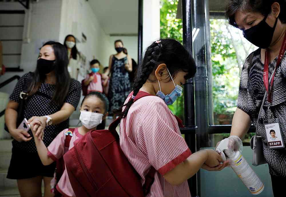 Children wearing protective face masks sanitise their hands as they attend preschool classes at St James' Church Kindergarten in Singapore June 2, 2020. u00e2u20acu201d Reuters pic
