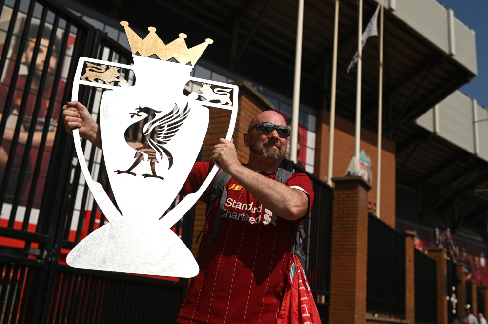 Liverpool fan Paul Davies poses with a cut out of a trophy outside Anfield stadium in Liverpool, north-west England June 26, 2020 after Liverpool FC sealed the Premier League title the previous evening. u00e2u20acu201d AFP pic 