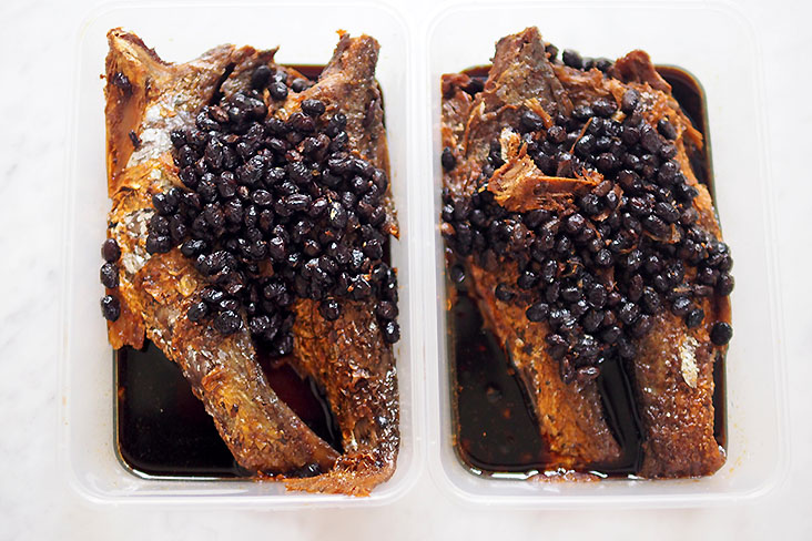 The fried fish with salted black beans are packed in plastic boxes.