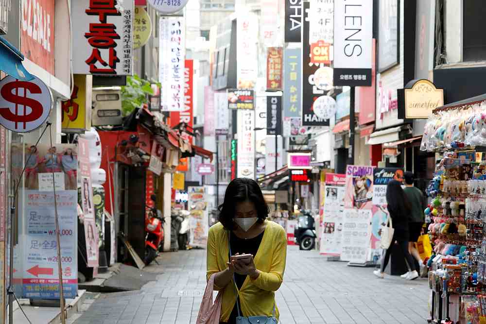 A woman wearing a mask looks at her mobile phone amid social distancing measures to avoid the spread of Covid-19, in Myeongdong shopping district in Seoul, South Korea May 28, 2020. u00e2u20acu201d Reuters pic