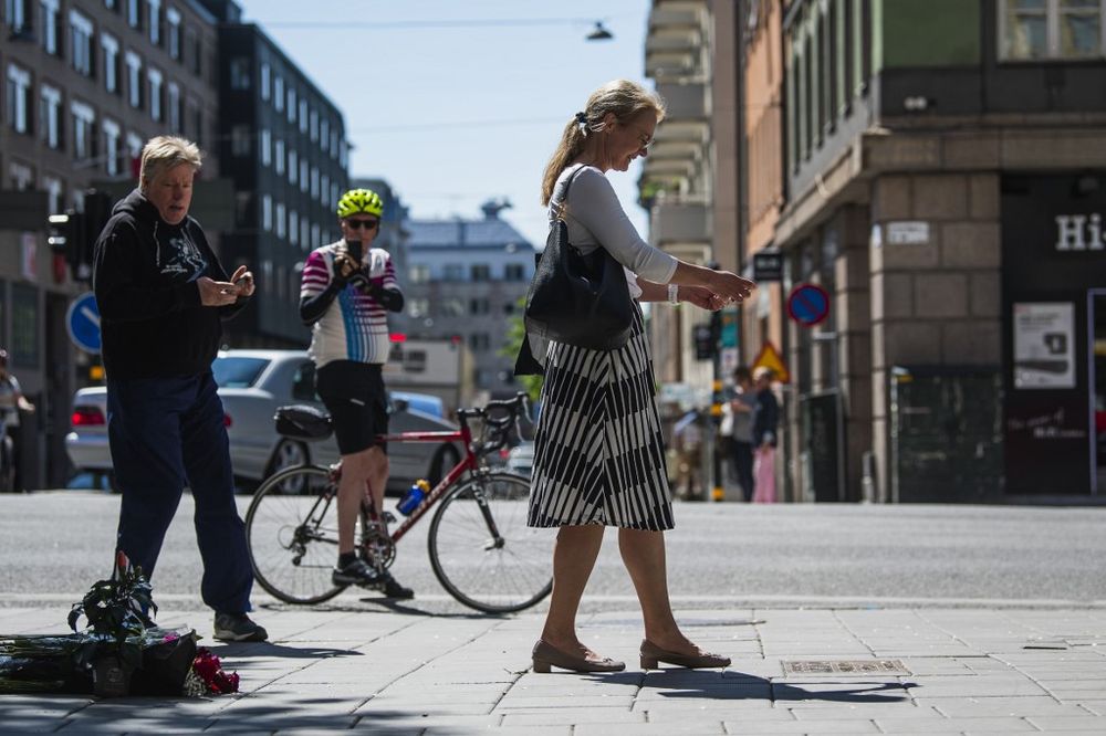Pedestrians take pictures of the memorial plaque at the corner between Sveavagen and Tunnelgatanthe streets in Stockholm, where late Swedish Prime Minister Olof Palme was murdered in February 1986, on June 10, 2020. u00e2u20acu201d AFP pic