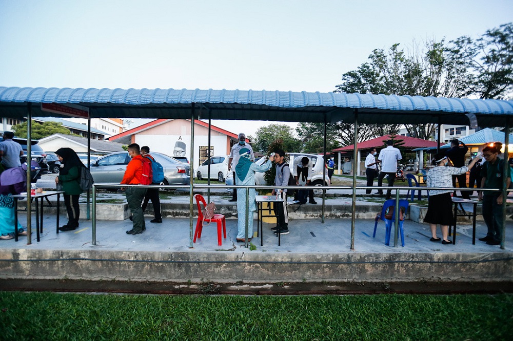 Students get their temperatures checked before entering the classroom at SMK Raja Tun Uda in Bayan Baru June 24, 2020. u00e2u20acu2022 Picture by Sayuti Zainudin