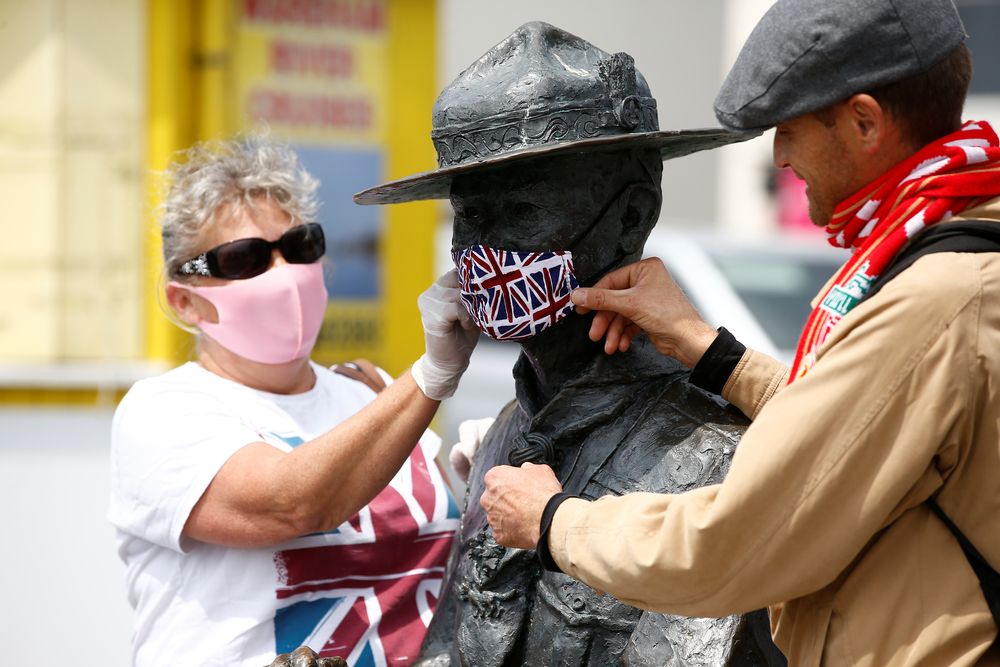 People are seen putting a face mask onto a statue of Robert Baden-Powell in Poole, the statue is due to be removed following protests against the death of George Floyd who died in police custody in Minneapolis, Poole, Britain, June 11, 2020. u00e2u20acu201d Reuters p