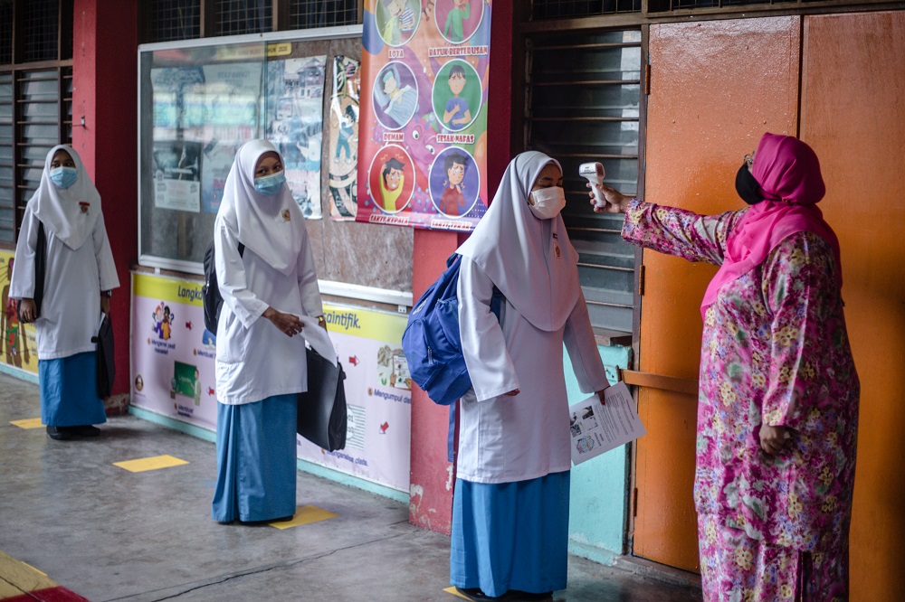 A student gets her temperature checked before entering the classroom at SMK Lembah Keramat Jaya in Kuala Lumpur June 24, 2020. u00e2u20acu2022 Picture by Firdaus Latif