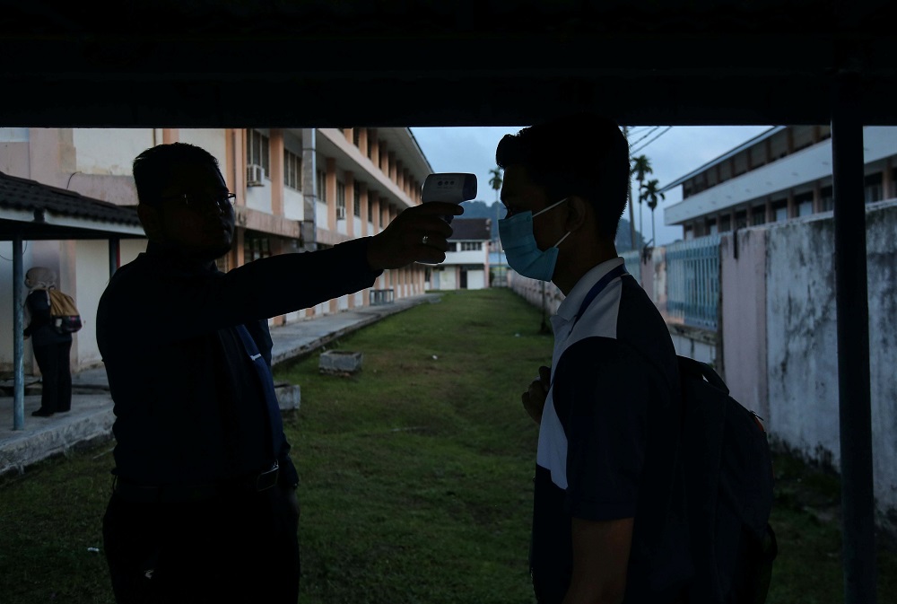 A student gets her temperature checked before entering the classroom at SMK Anderson in Ipoh June 24, 2020. u00e2u20acu2022 Picture by Farhan Najib