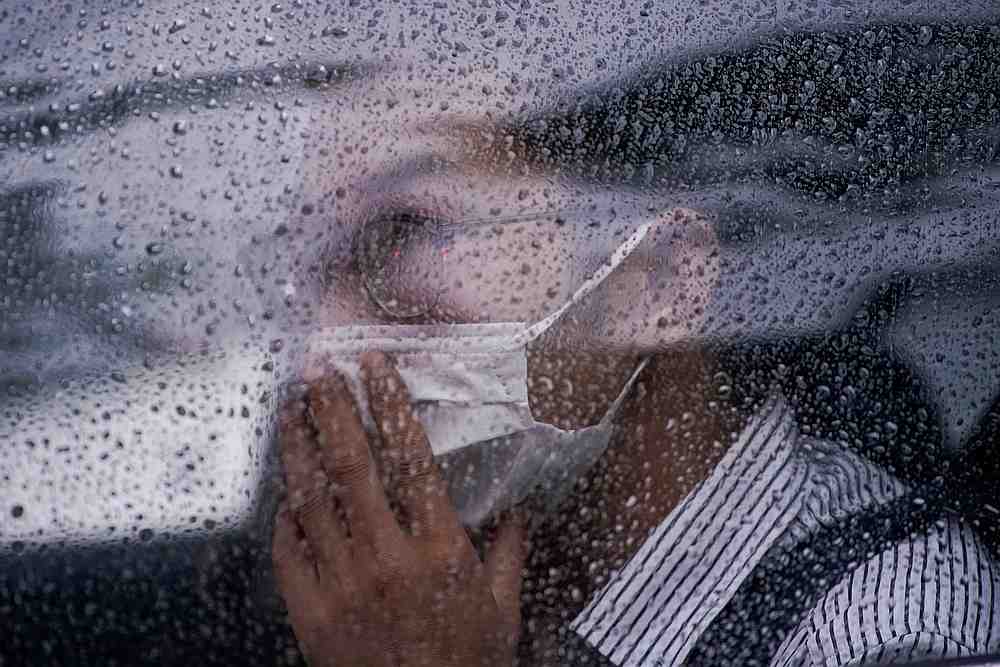 A man wearing face mask sits inside a car during a raining day in Shanghai, following the Covid-19 outbreak, China June 18, 2020. u00e2u20acu201d Reuters pic