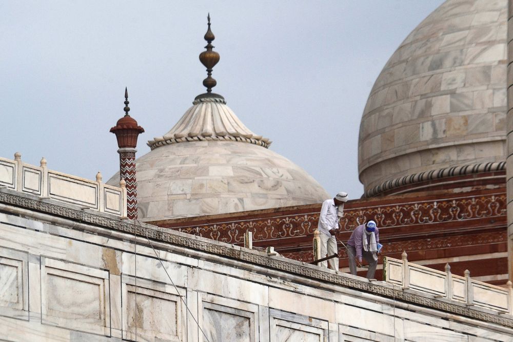 Workers stand on the railing of the Taj Mahal after it was damaged due to heavy rainstorm in Agra May 30, 2020. u00e2u20acu201d AFP pic