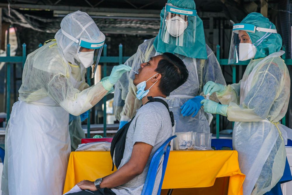 A man undergoes a swab test during a Covid-19 screening exercise in Taman Langat Utama June 3, 2020. u00e2u20acu201d Picture by Hari Anggara 