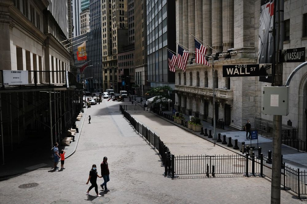 People walk by the New York Stock Exchange (NYSE) in an empty Financial District on June 15, 2020 in New York City. u00e2u20acu201d Getty Images via AFP