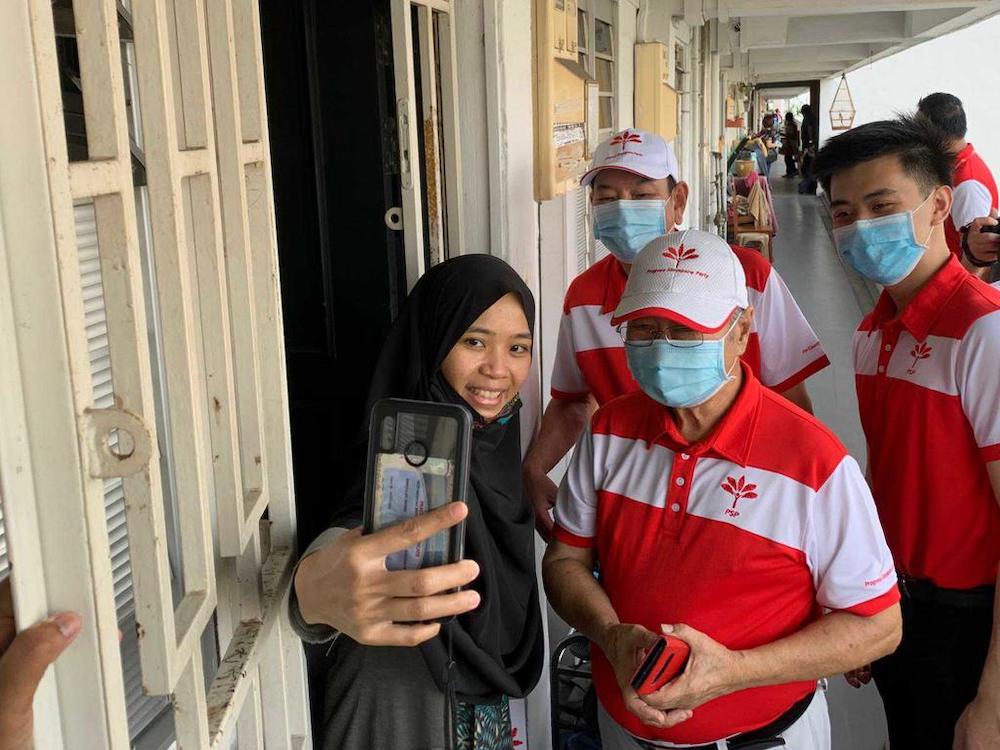 PSP chief Tan Cheng Bock (2nd right) with candidates for Chua Chu Kang GRC Choo Shaun Ming and Francis Yuen taking a selfie with a resident at Blk 9 Teck Whye Lane, July 3, 2020. u00e2u20acu201d TODAY pic