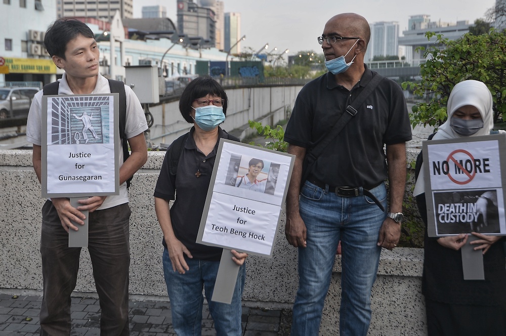 People hold placards during the Malaysia's Custodial Death Black Thursday organised by Eliminating Death & Abuse In Custody Together at the Klang River in Kuala Lumpur July 16, 2020. u00e2u20acu201d Picture by Shafwan Zaidon