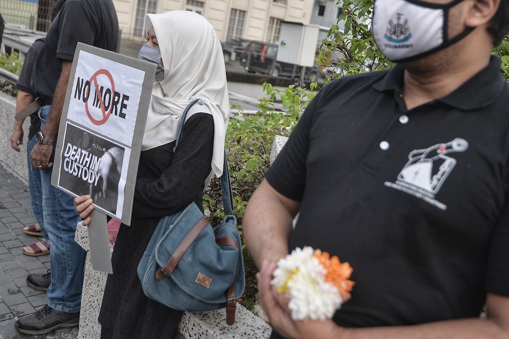 People hold placards during the Malaysia's Custodial Death Black Thursday organised by Eliminating Death & Abuse In Custody Together at the Klang River in Kuala Lumpur July 16, 2020. u00e2u20acu201d Picture by Shafwan Zaidon