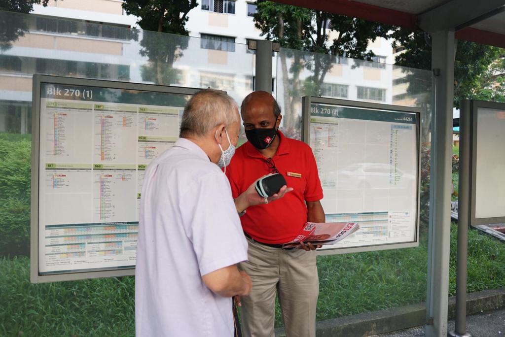 Dr Paul Tambyah (right) from the SDP distributes flyers to residents at a bus stop at Block 270, Bangkit Road on July 6, 2020. u00e2u20acu201d TODAY pic