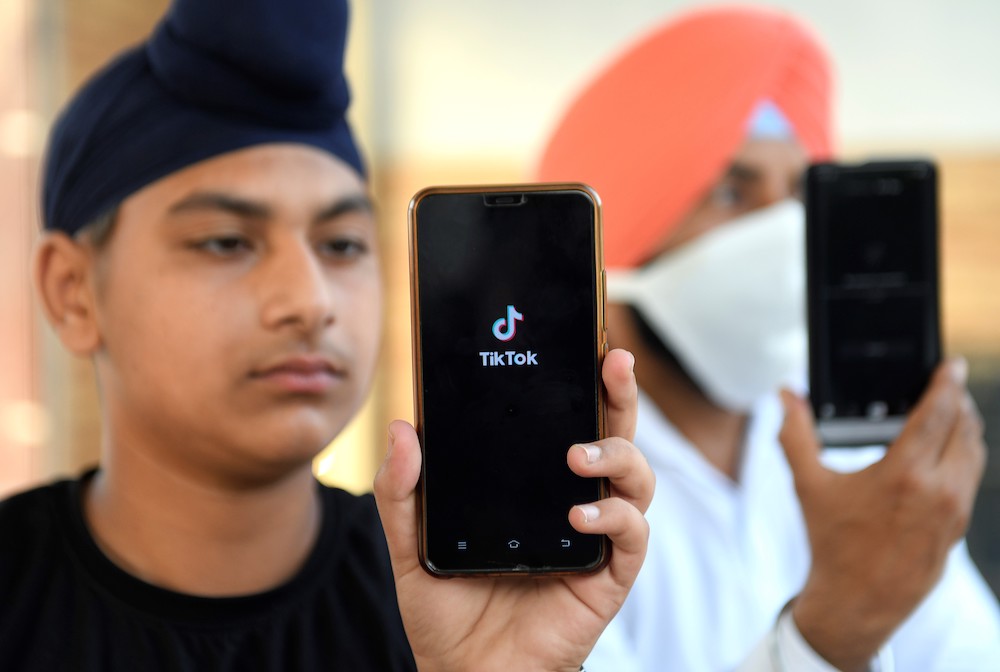 In this file photo taken on June 30, 2020, Indian mobile users browse through the Chinese owned video-sharing 'Tik Tok' app on smartphones in Amritsar. u00e2u20acu201d AFP pic