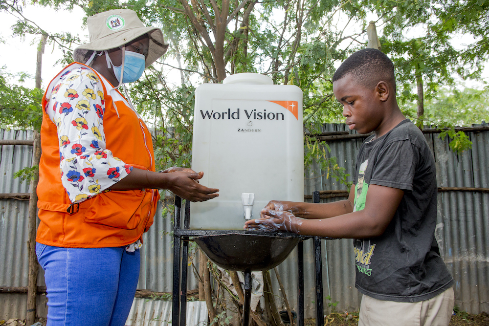 A World Vision staff member teaches a young boy the importance of being thorough when washing hands. — Picture courtesy of World Vision Malaysia
