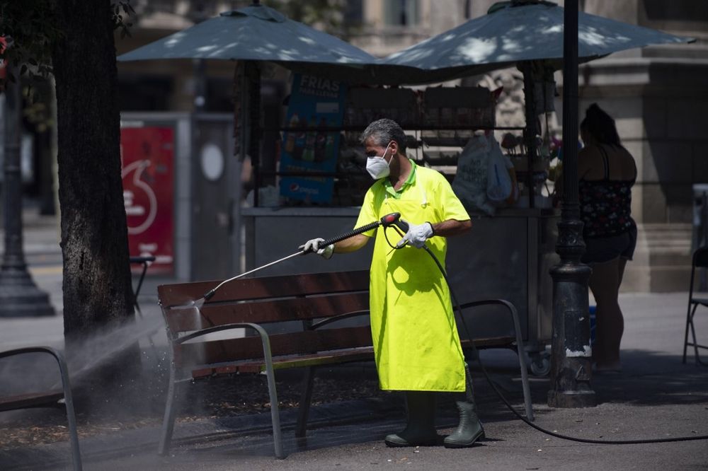 A municipal worker cleans a bench at Catalonia square in Barcelona on July 18, 2020. Four million residents of Barcelona have been urged to stay at home as virus cases rise. u00e2u20acu201d AFP pic