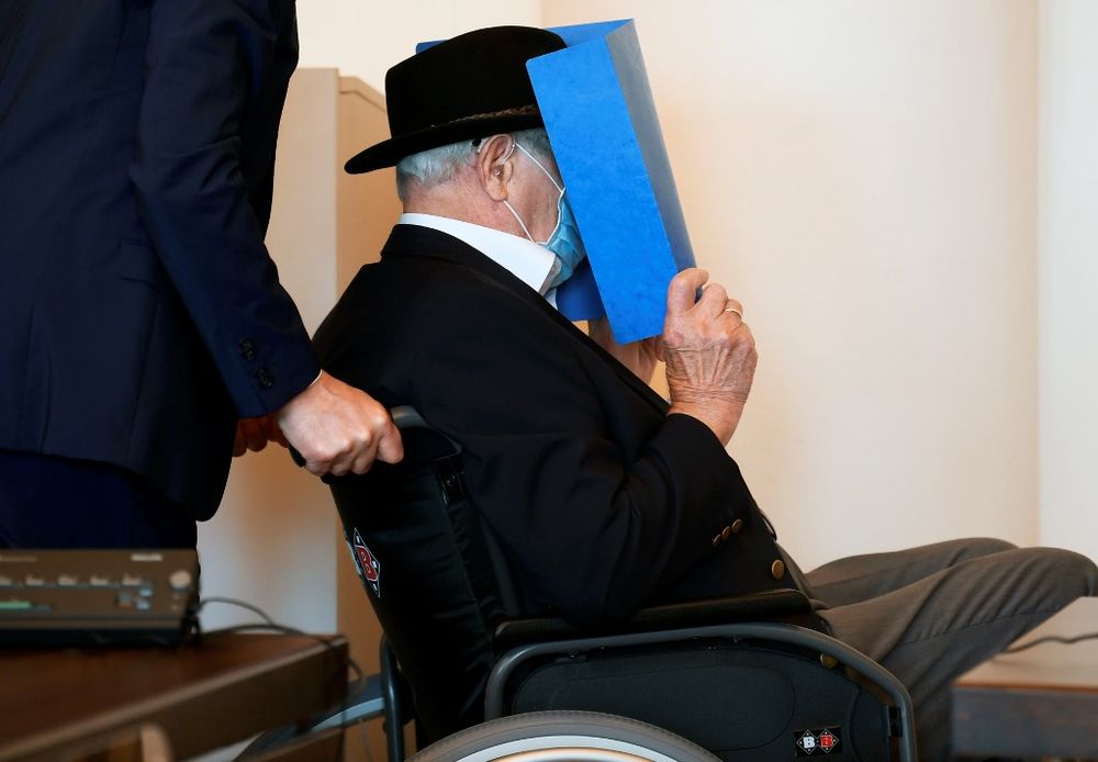 Bruno Dey, a former SS-watchman at the Stutthof concentration camp, hides his face behind a folder as he arrives on a wheelchair for a hearing in his trial on July 23, 2020 in Hamburg, northern Germany. u00e2u20acu201d AFP pic