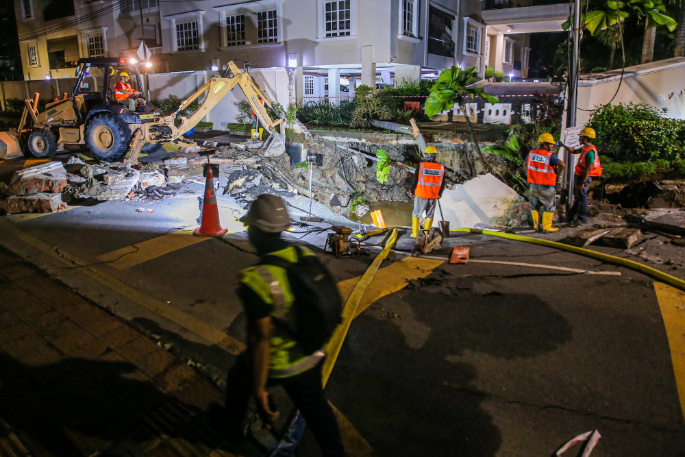Air Selangor contractors are pumping water from a sinkhole that occurred at Residency 16, Jalan Taman U Thant July 19, 2020. — Picture by Hari Anggara