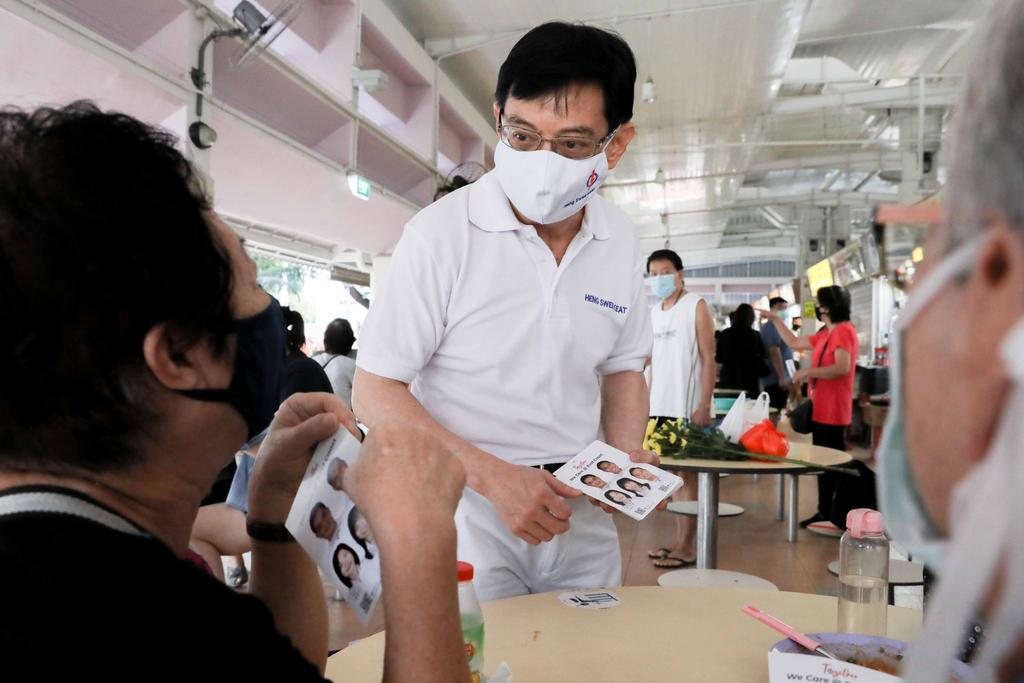 Mr Heng Swee Keat from the Peopleu00e2u20acu2122s Action Party speaks to a resident during a walkabout at Block 216 Bedok Food Centre and Market on Friday, July 3, 2020. u00e2u20acu201d TODAY picnn