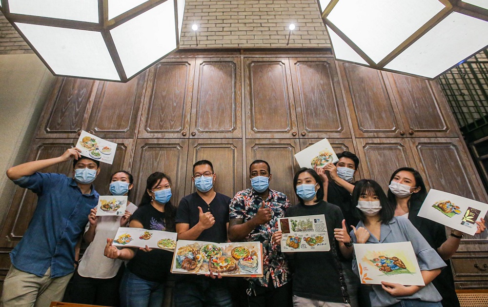 Eight members of the KL Urban Sketchers group showing their food sketches in Jibby by the Park cafe. u00e2u20acu201d Picture by Hari Anggara
