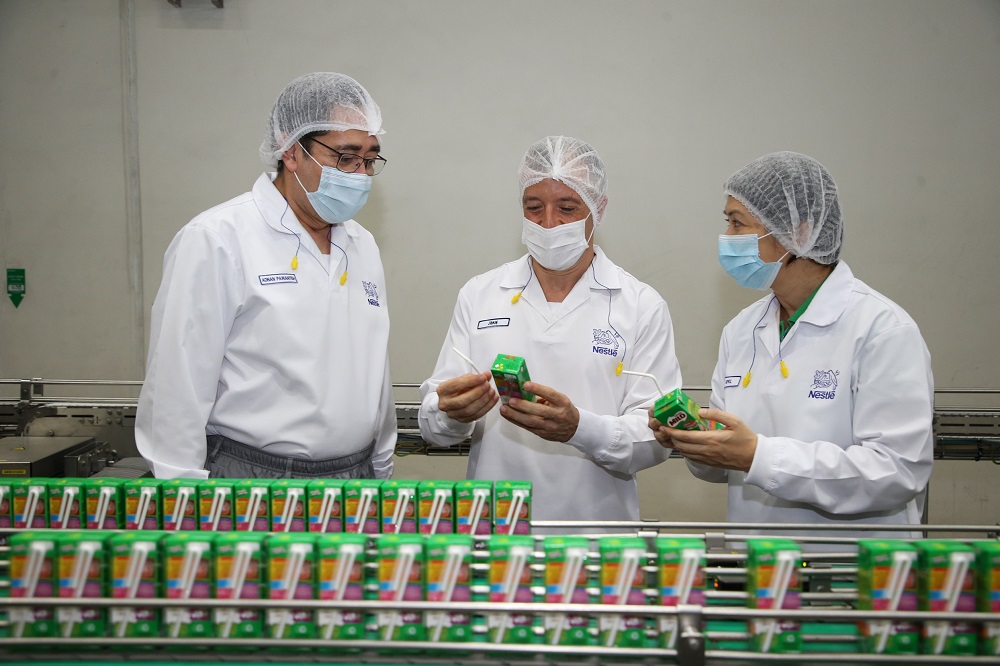 Datuk Adnan Hisham Pawanteh, Juan Aranols and April Wong inspecting the production line for the Nestlé UHT range with 100% paper straws. ― Picture courtesy of Nestle Malaysia Berhad