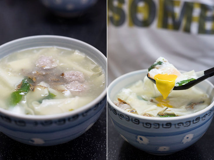 Yolk spilling out from a poached egg into 'mee hoon kueh' soup
