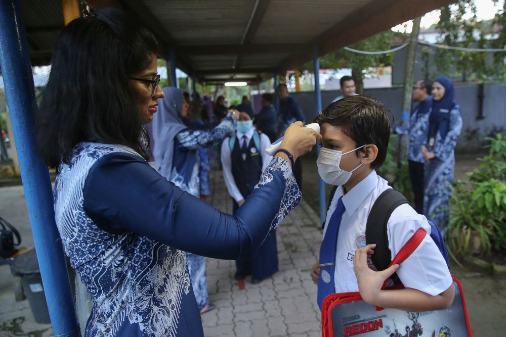 Sekolah Kebangsaan Seksyen 6 students have their temperature checked on their first day back at school in Shah Alam July 15, 2020. u00e2u20acu201d Picture by Yusof Mat Isa
