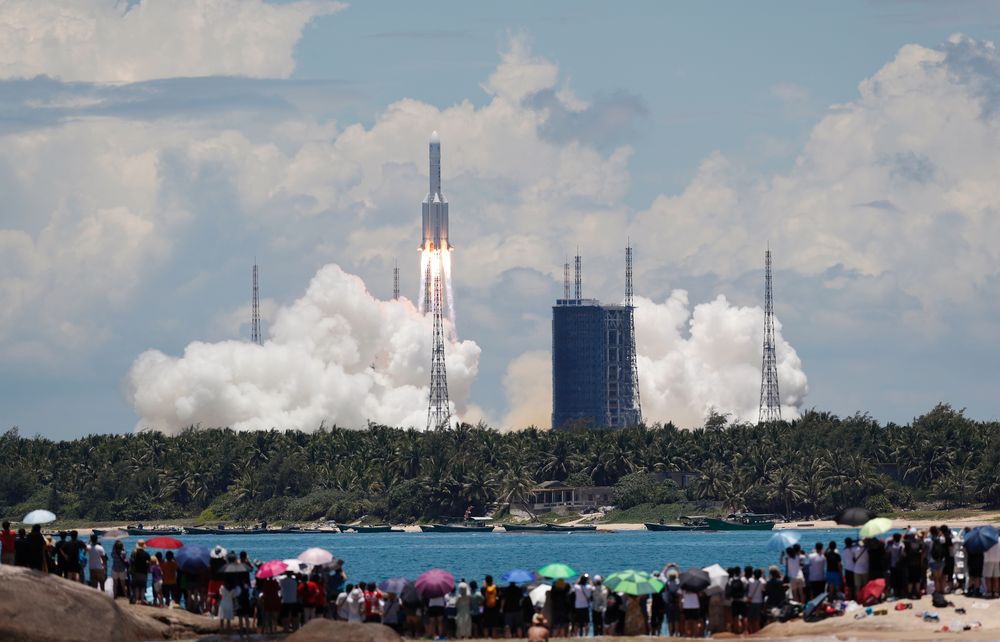 People watch from a beach as the Long March 5 Y-4 rocket, carrying an unmanned Mars probe of the Tianwen-1 mission, takes off from Wenchang Space Launch Center in Wenchang, Hainan province, China July 23, 2020. u00e2u20acu201d China Daily pic via Reuters