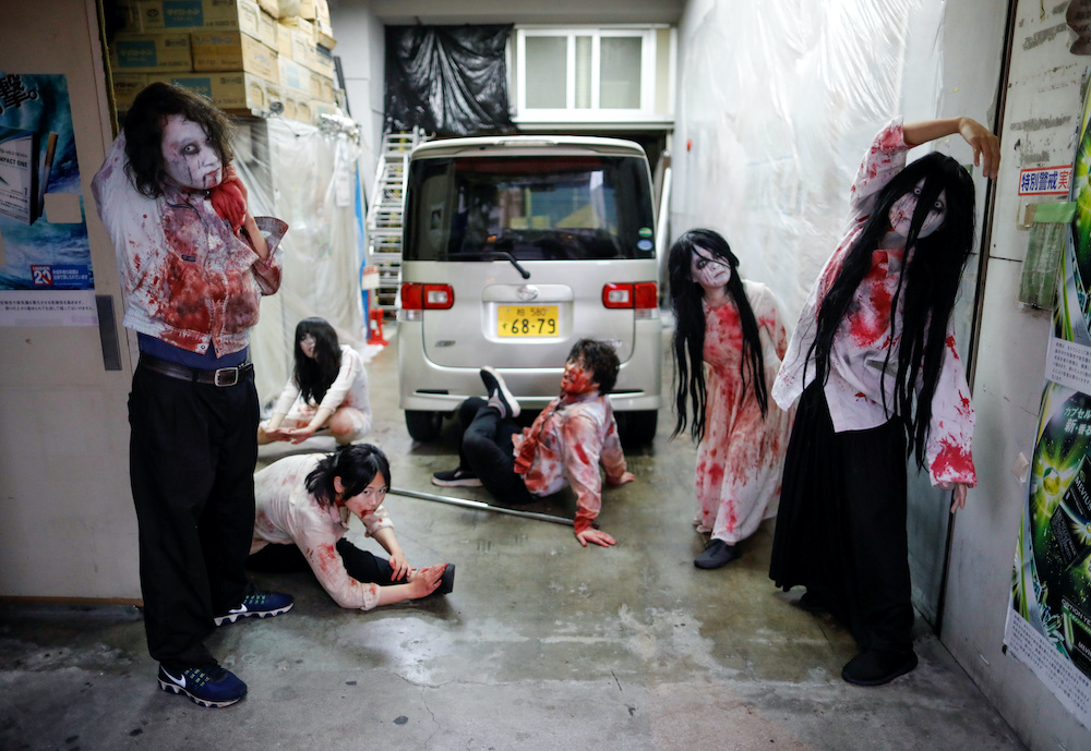 Actors dressed as zombies or ghouls stretch before their performance at a drive-in haunted house show at a garage in Tokyo, Japan July 3, 2020. u00e2u20acu201d Reuters pic