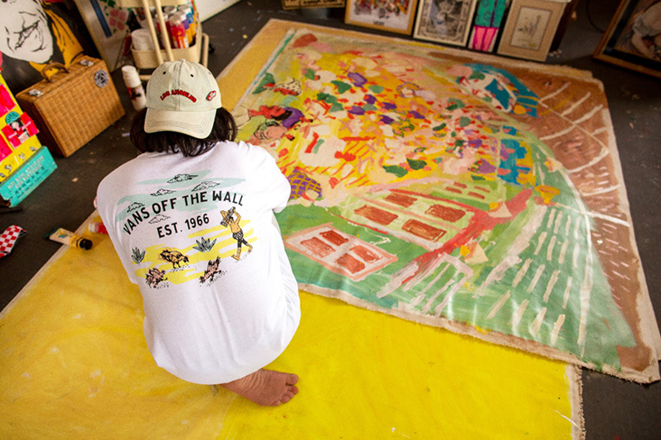 Kide at work creating another of his colourful paintings of small town life