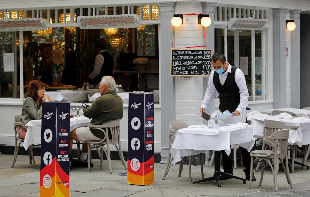 A waiter wearing a face mask a precautionary measure against spreading Covid-19, works at a recently re-opened restaurant in central London July 6, 2020. u00e2u20acu201d AFP pic 