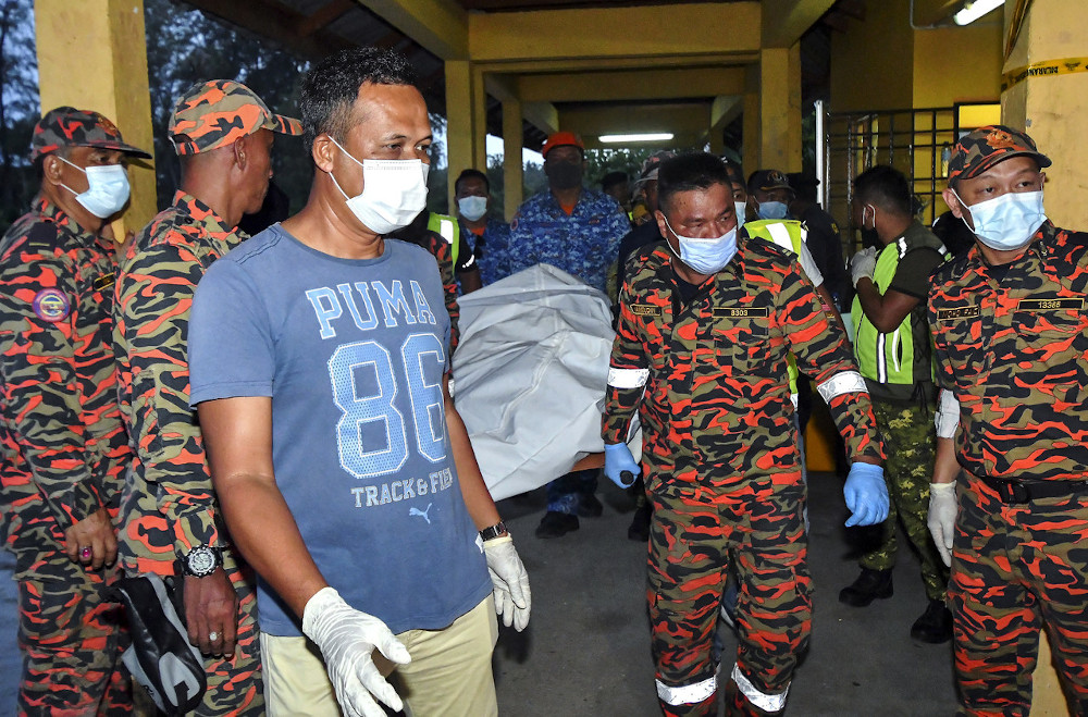 The body of a sixth victim Harun Daud is carried by Fire and Rescue personnel at the Kuala Kemasin Jetty in Bachok, July 2, 2020. u00e2u20acu201d Bernama pic 