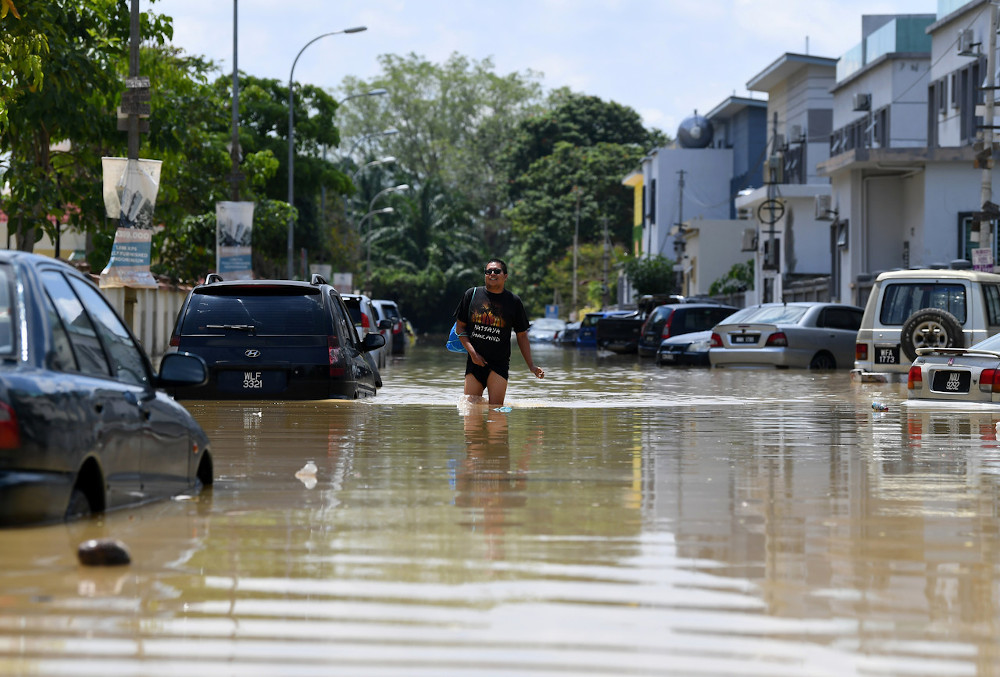 A resident walks in a flooded street in Dengkil July 19, 2020. u00e2u20acu201d Bernama pic
