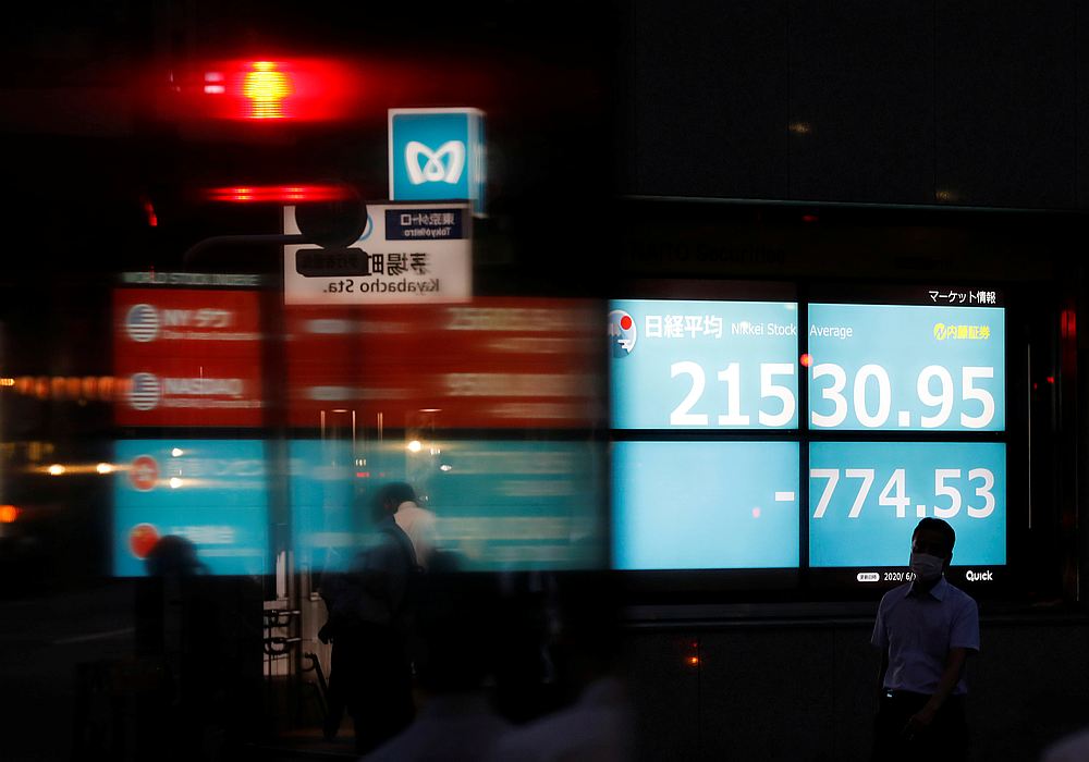 A man wearing a protective face mask, following the Covid-19 outbreak, is silhouetted in front of a stock quotation board outside a brokerage in Tokyo, Japan June 15, 2020. u00e2u20acu201d Reuters pic