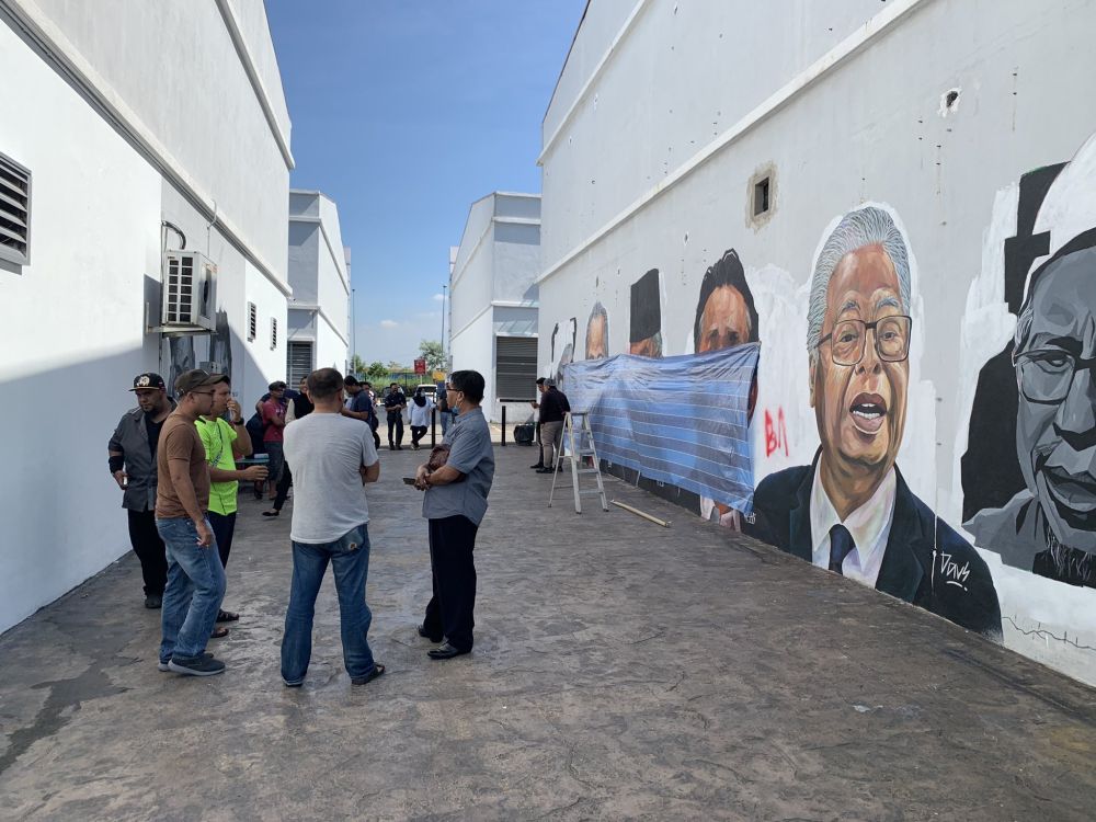 The popular mural, which is believed to have been defaced by vandals, is seen covered with a piece of tarpaulin. u00e2u20acu201d Picture via Twitter