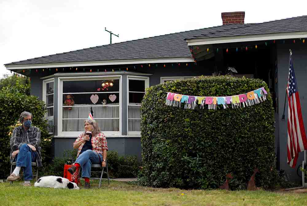 Lani and Nancy Lain sit on their front lawn with their dog Gus as they host their daughter's birthday party, while practising social distancing in Pasadena, California June 28, 2020. u00e2u20acu201d Reuters pic