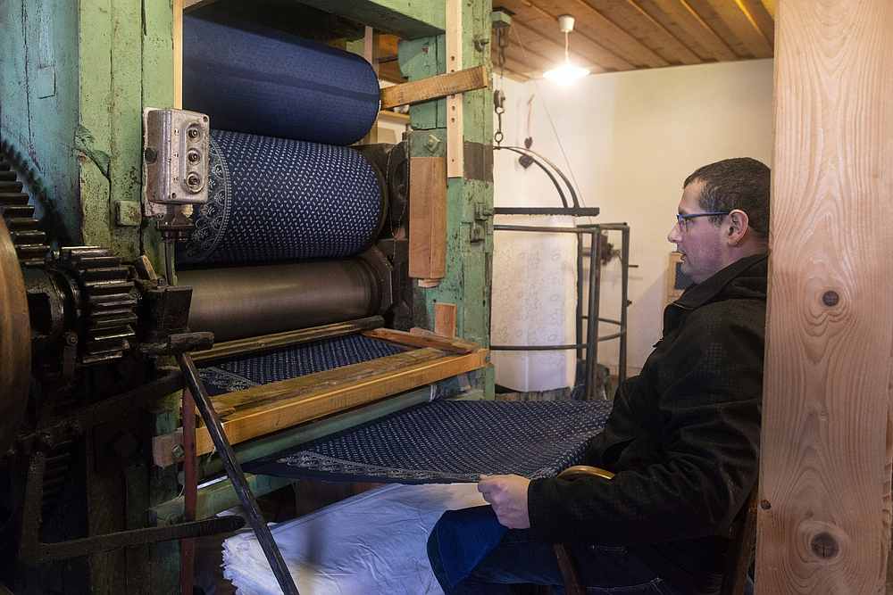 Czech craftsman Jiri Danzinger works with a rolling press at his blueprint workshop. u00e2u20acu201d AFP pic