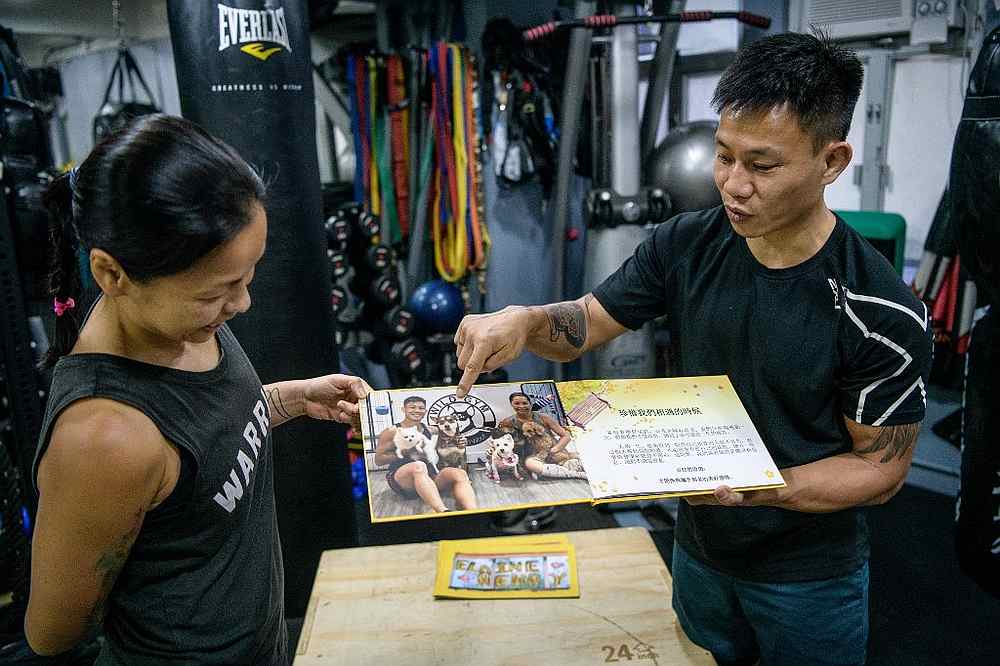 Elaine To (left), 41, and Henry Tong, 39, hold up a photo book which they had printed to keep with them in prison if found guilty, during an interview at their fitness studio in Hong Kong June 22, 2020. u00e2u20acu201d AFP pic