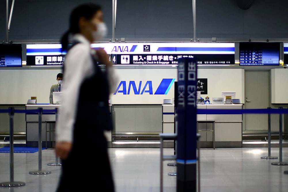 An employee, wearing protective mask following the Covid-19 outbreak, walks in an almost empty Kansai International Airport in Osaka, Japan,March 14, 2020. u00e2u20acu201d Reuters pic