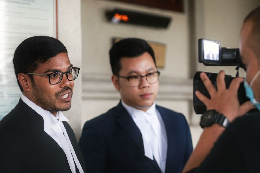 Lawyer Farhan Shafee (left) speaks to reporters that the Kuala Lumpur High Court July 22,2020. — Picture by Ahmad Zamzahuri