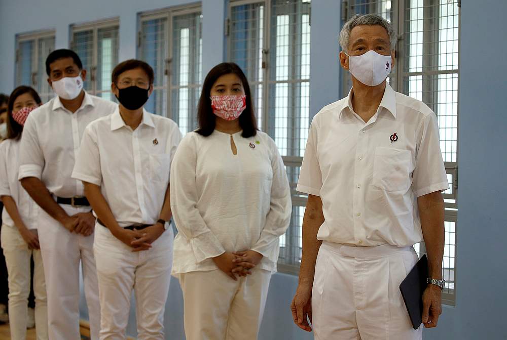 Singapore's Prime Minister Lee Hsien Loong (right) of the ruling People's Action Party wearing a face mask, waits to give a speech at a nomination centre in Singapore June 30, 2020. u00e2u20acu201d Reuters pic